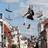 Bild vergrößern: In der Norderstrae in Flensburg werden alte Schuhpaare traditionell ueber Leitungen geworfen, die ueber die Strae gespannt sind