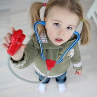 Bild vergrößern: Ein Kind spielt mit einem Stethoskop