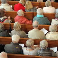 Bild vergrößern: Rentner in den Reihe während eines Gottesdienstes